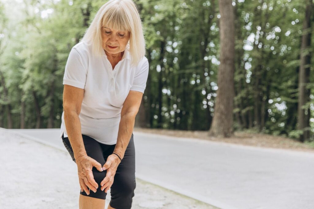 Elderly woman injured her leg while running walking standing park holding his knee feeling severe pain closeup photo 1429 25369 Elderly woman injured her leg while running walking standing park holding his knee feeling severe pain closeup photo 1429 25369