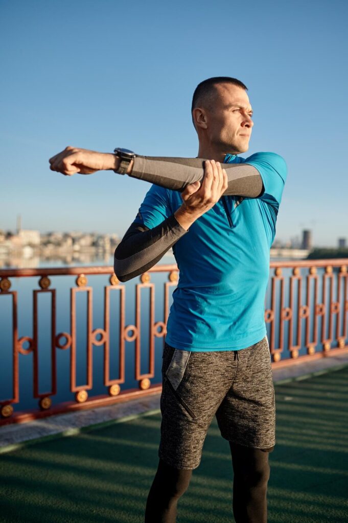 Fitness runner doing warm up routine before speed running man stretching arms muscles preparing cardio workout fast jogging closeup view 266732 32025 Fitness runner doing warm up routine before speed running man stretching arms muscles preparing cardio workout fast jogging closeup view 266732 32025