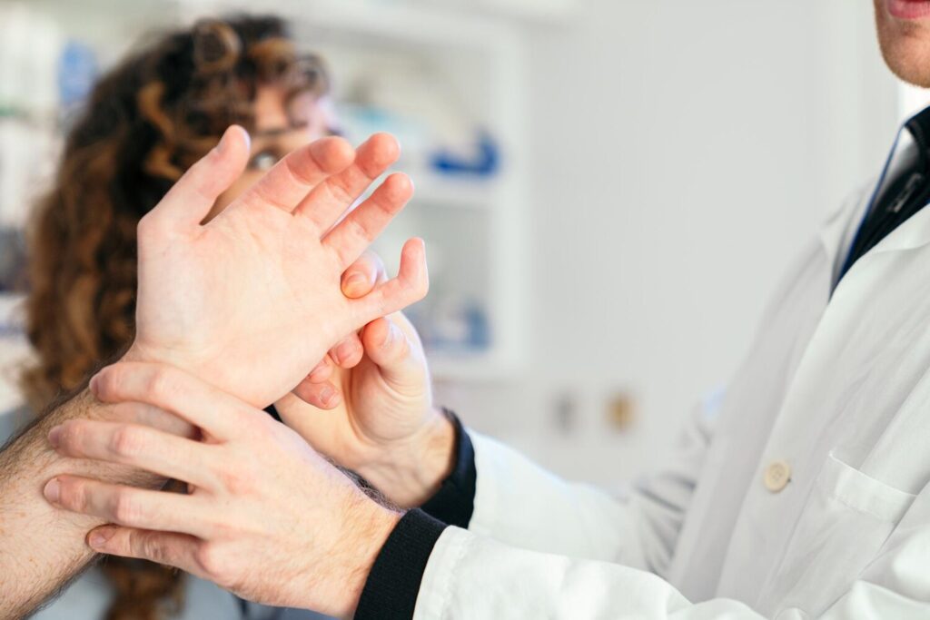 Physician nurse meticulously examine patients bent finger 198115 2596 Physician nurse meticulously examine patients bent finger 198115 2596